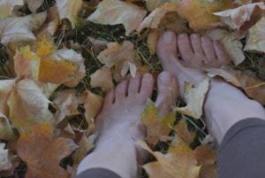 A person 's feet are shown in the leaves.