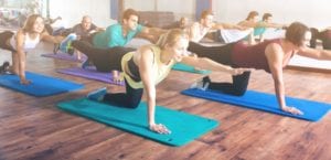 A group of people doing yoga on mats.